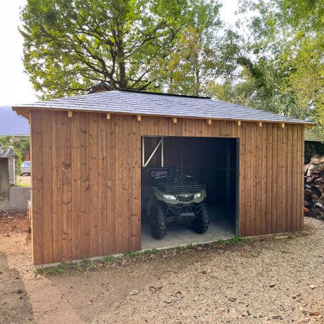 Cabanon terminé par Sweelco. Façade en bois, toiture en ardoise, porte de garage.