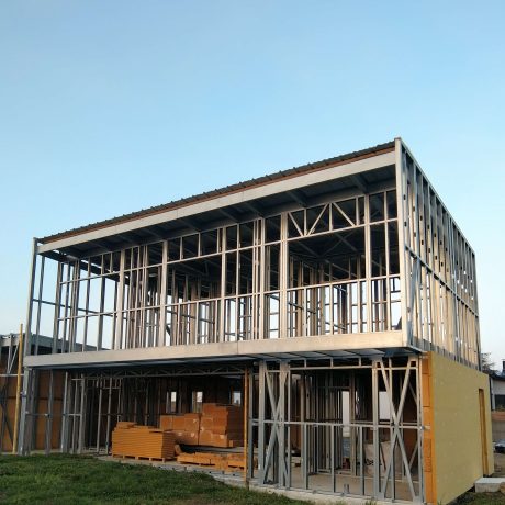 Vue de montage des panneaux de construction de maison individuelle à Chalonnes-sur-Loire (49) par Sweelco Montage des panneaux de construction pour une maison individuelle à Chalonnes-sur-Loire par Sweelco, avec panneaux métalliques visibles.