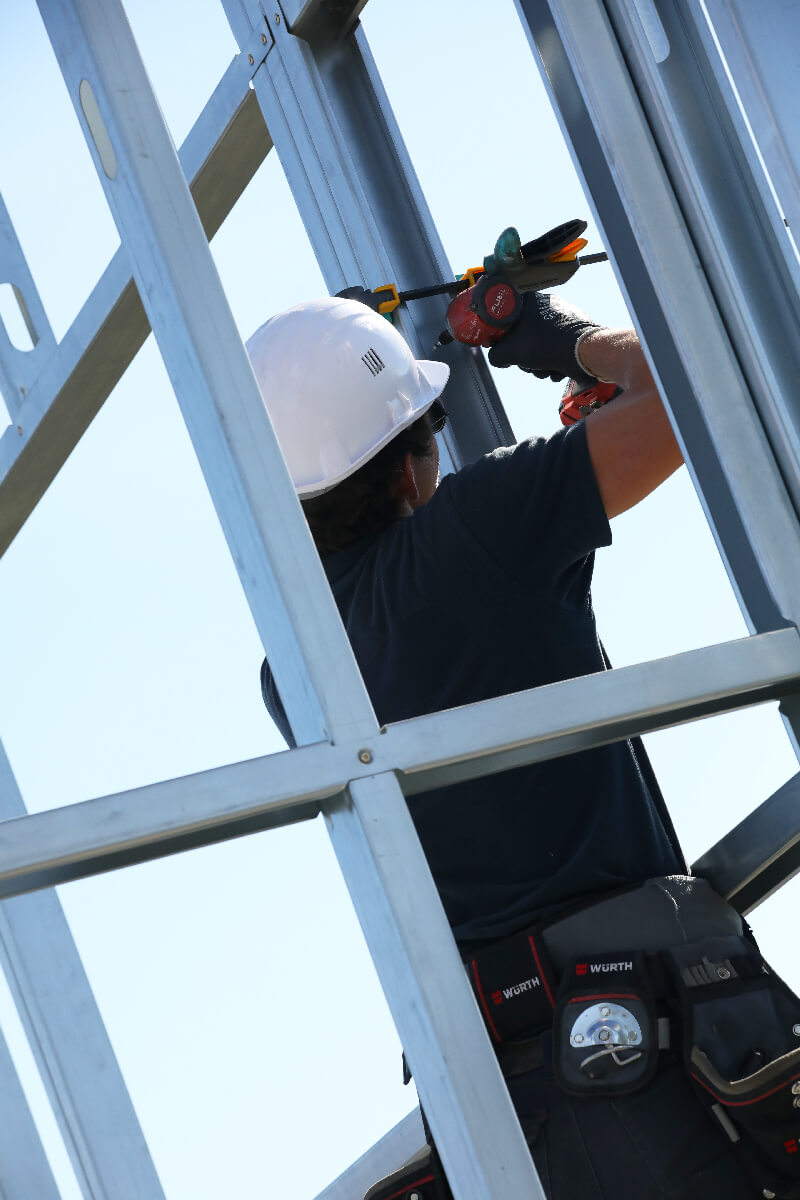 Ouvrier de Sweelco en pleine installation de structure métallique à Angers, utilisant des outils professionnels Würth pour assurer une construction solide et sécurisée.